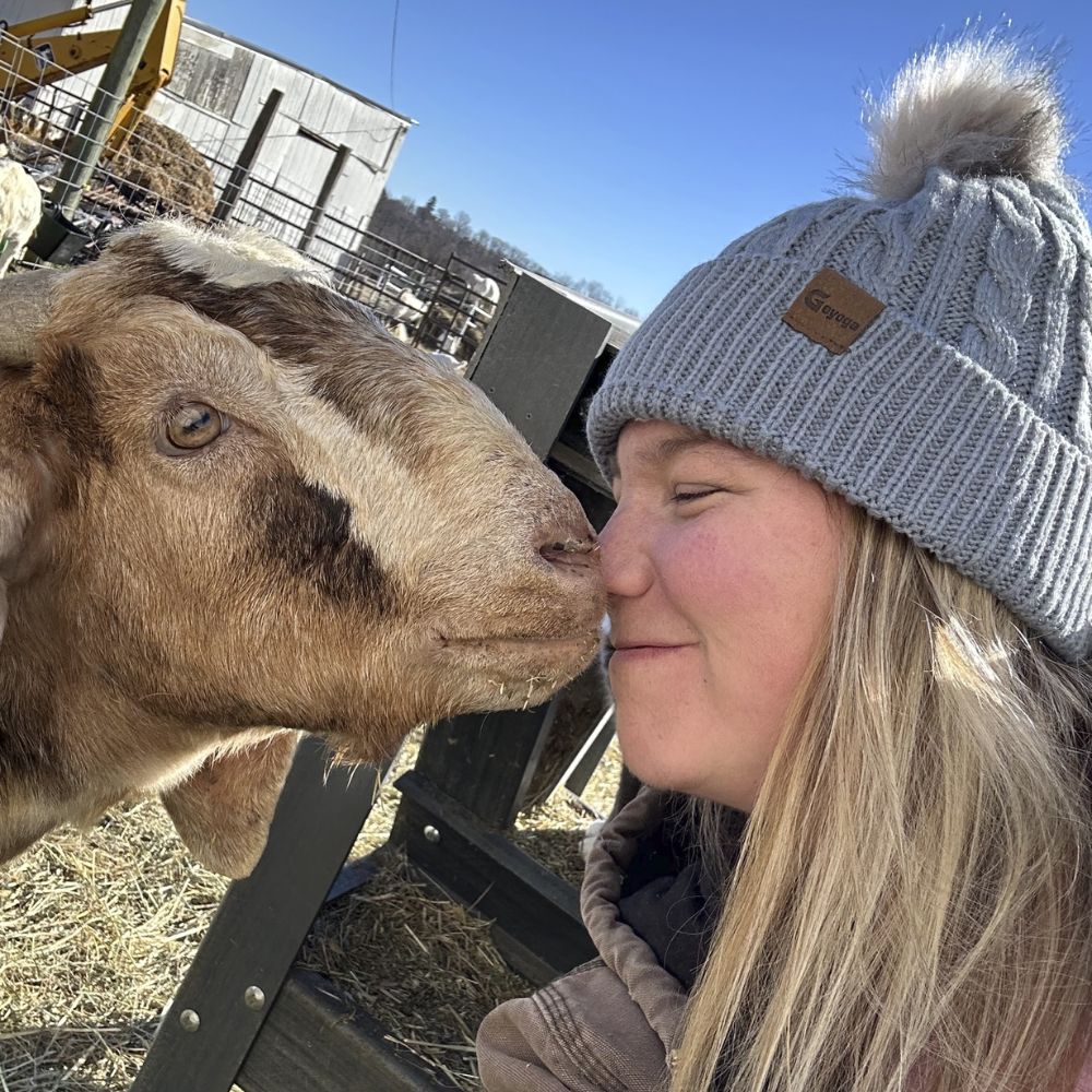 A lady affectionately playing with a goat